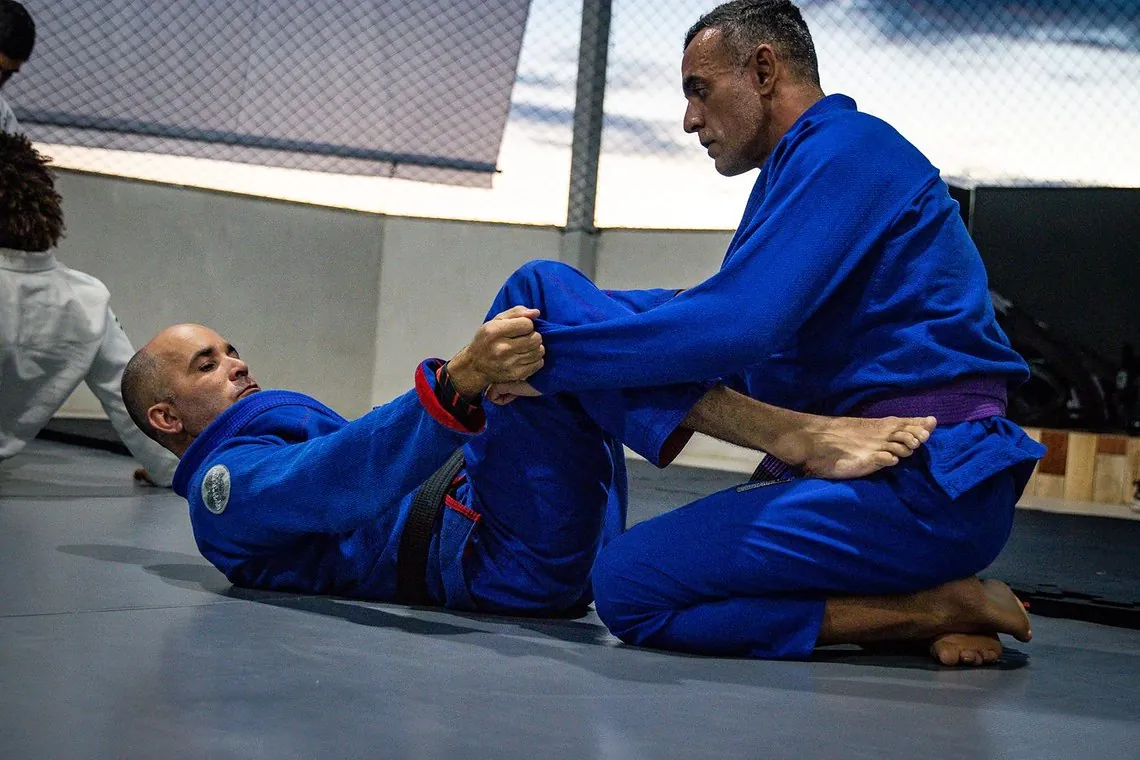 Professor corrigindo a técnica de um aluno